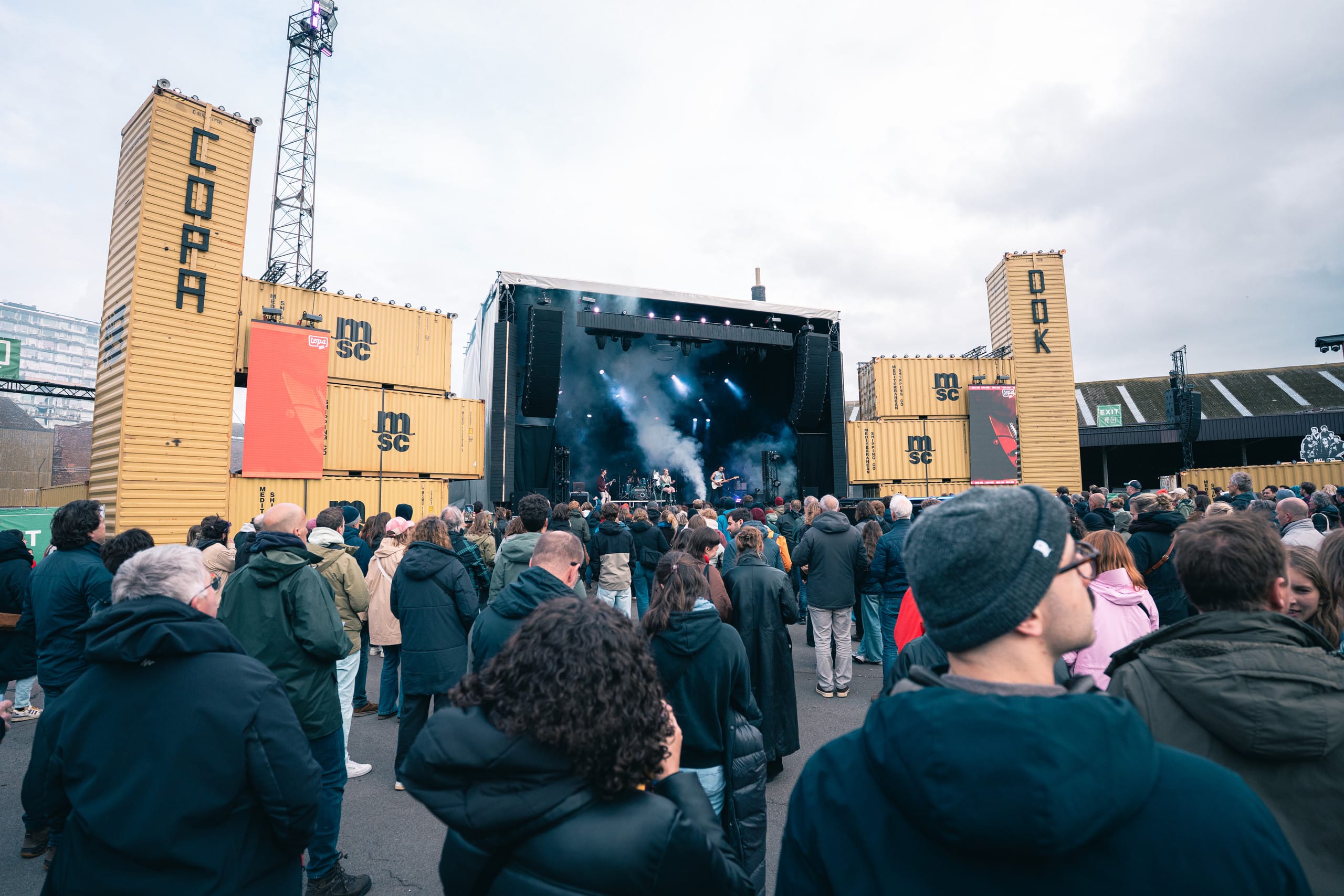 De Lion tussen gele zeecontainers in de haven van Gent bij blauw uur