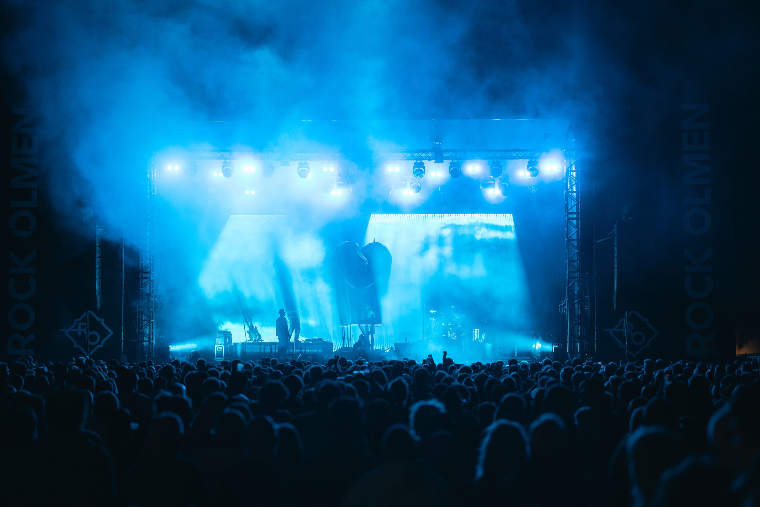 Publiek en gitarist in oranje rook tijdens Rock Olmen